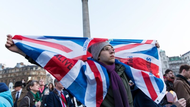 Ein Teilnehmer der Gedenkfeier hüllt sich in die britische Flagge. (Bild: AFP)