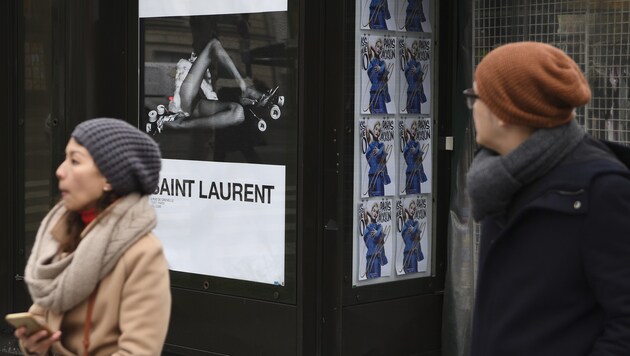 Passanten in Paris schlendern an einem der umstrittenen Plakate vorbei. (Bild: AFP)