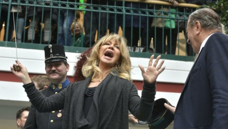 Goldie Hawn dirigiert eine Blasmusikkapelle im Rahmen der Autogrammstunde in der Lugner City. (Bild: APA/HERBERT PFARRHOFER)