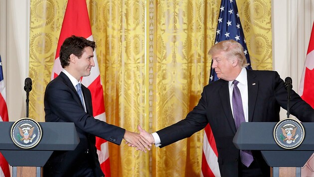 Trump und Trudeau reichen einander demonstrativ die Hände. (Bild: ASSOCIATED PRESS)