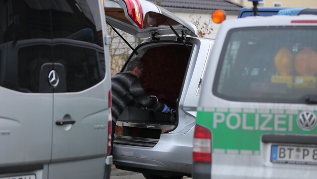 Ein Mitarbeiter eines Bestattungsinstituts lädt einen Sarg in den Leichenwagen. (Bild: APA/dpa/Daniel Karmann)