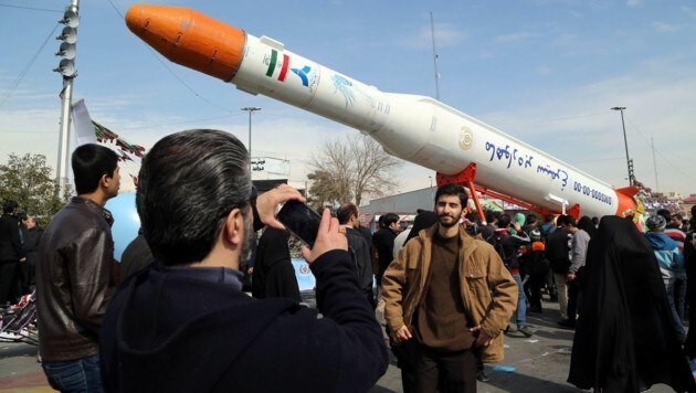 Ein Iraner macht einen Schnappschuss vor einer "Phönix"-Rakete. (Bild: AFP)