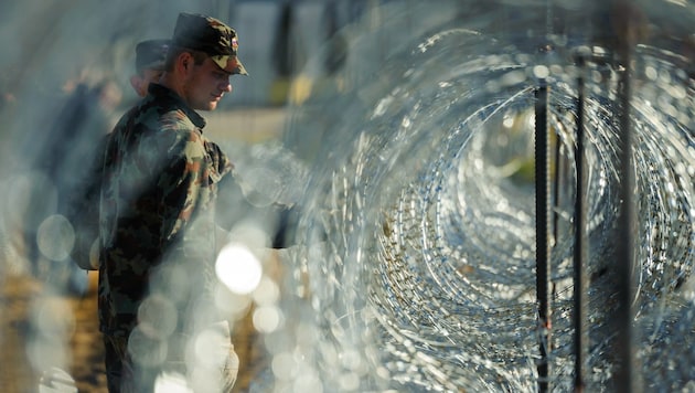 Slowenische Soldaten kontrollieren eine Grenzsperre. (Bild: APA/AFP/Jure Makovec)