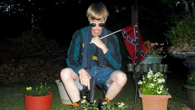 Dylann Roof auf einem seiner zahlreichen schaurigen Bilder mit Waffe und Konföderierten-Flagge (Bild: AP)