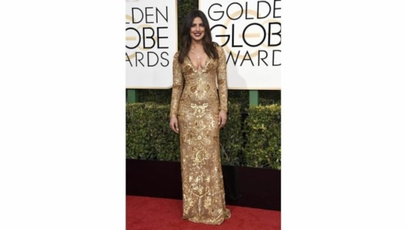 Priyanka Chopra strahlte in ihrer goldenen Robe von Ralph Lauren mit den Trophäen um die Wette. (Bild: APA/AFP/GETTY IMAGES/Frazer Harrison)