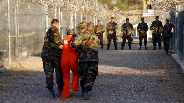 US-Soldaten mit einem Gefangenen im berüchtigten Guantanamo-Militärgefängnis auf Kuba (Bild: Shane T. Mccoy/EPA/picturedesk.com)