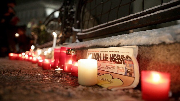 Kerzen und eine "Charlie Hebdo"-Ausgabe vor der französischen Botschaft in Wien (Bild: APA/GEORG HOCHMUTH)