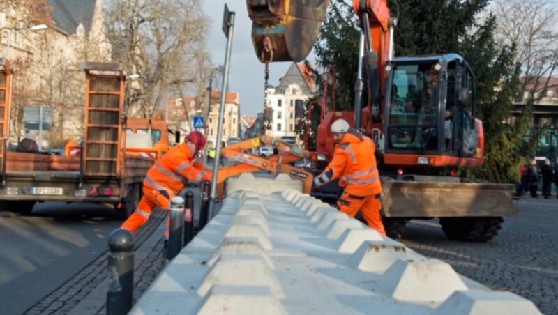 Betonpoller werden rund um den Weihnachtsmarkt in Erfurt positioniert. (Bild: AP)