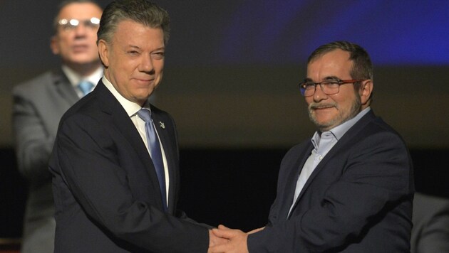 Präsident Santos (links) und FARC-Führer Londono bei der Unterzeichnung des Vertrags (Bild: APA/AFP/LUIS ROBAYO)