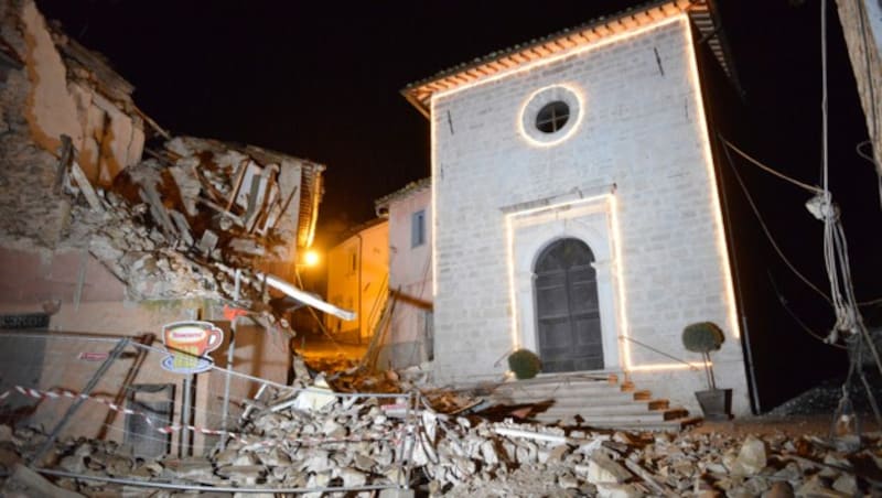 Zerstörte Häuser rund um die Kirche von Castelsantangelo sul Nera (Bild: ASSOCIATED PRESS)