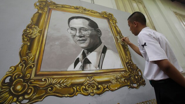 Ein thailändischer Schüler beim Verzieren eines Porträts des verstorbenen Königs Bhumibol (Bild: ASSOCIATED PRESS)
