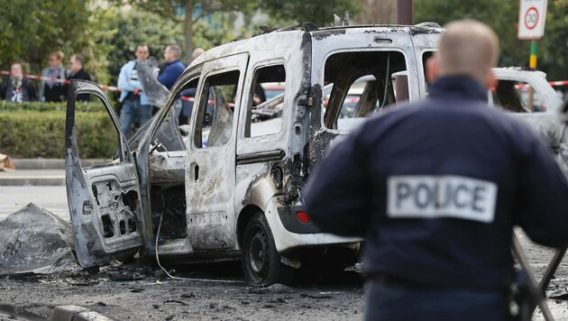 Die zwei Polizeiautos brannten komplett aus. (Bild: APA/AFP/THOMAS SAMSON)