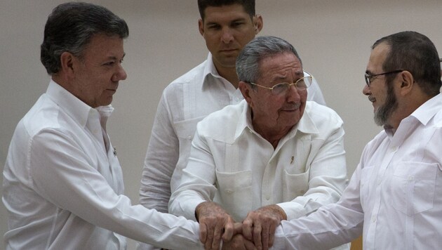 Historischer Deal: Santos, Kubas Staatschef Raul Castro und Rebellenführer Timoleon Jimenez (Bild: AP)