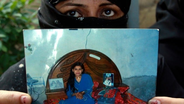 Die Mutter von Tasleem Solangi zeigt ein Bild ihrer Tochter, die Opfer eines Ehrenmordes wurde. (Bild: AP)
