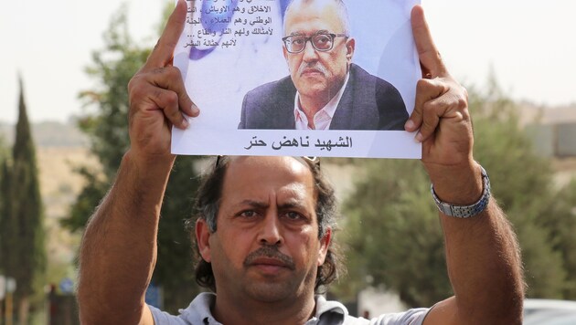 Ein Demonstrant hält ein Bild des getöteten Autors hoch, um seiner zu gedenken. (Bild: AP)