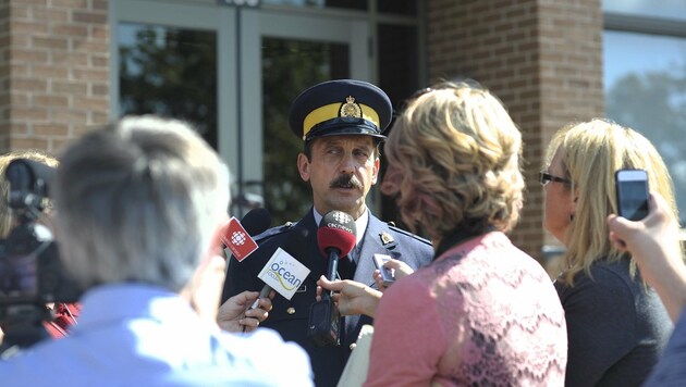 Ein Polizeisprecher informiert die Medien über die Evakuierungen und Schulschließungen. (Bild: ASSOCIATED PRESS)