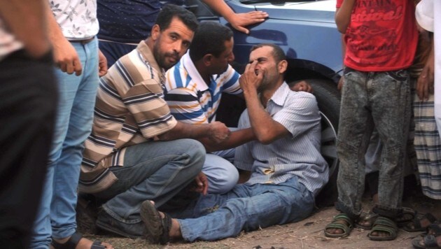 Ein verzweifelter Angehöriger wartet auf Nachrichten über das gekenterte Flüchtlingsboot. (Bild: EPA)