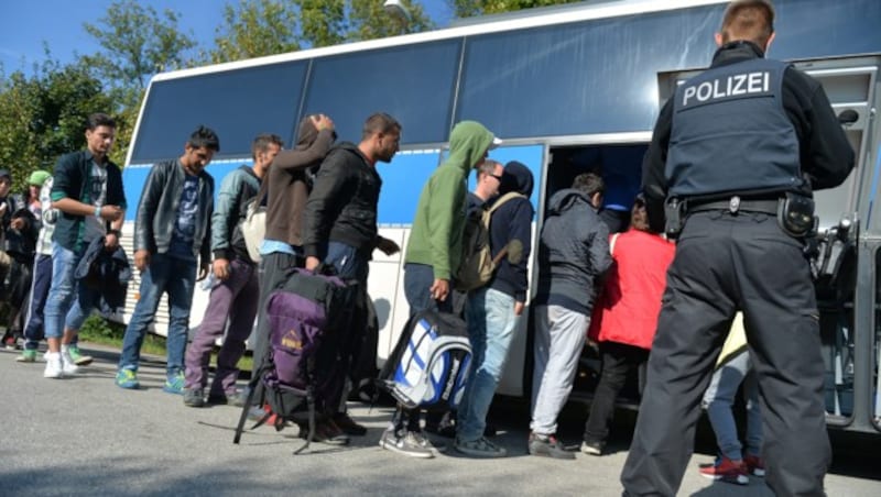 Ein deutscher Polizist mit Flüchtlingen am Grenzübergang in Freilassing (Bild: APA/BARBARA GINDL)