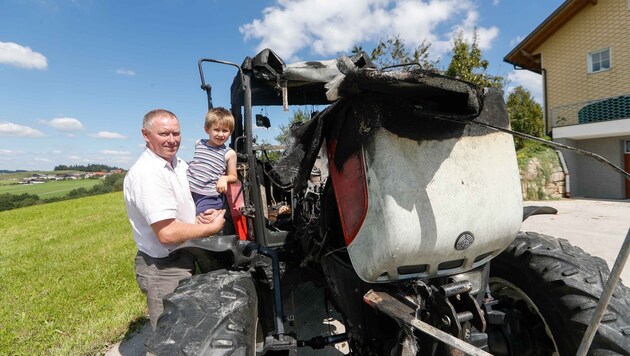 Der Held des Tages (4) mit Nachbar Josef Maurer neben dem völlig verbrannten Traktor. (Bild: Pressefoto Scharinger © Daniel Scharinger)