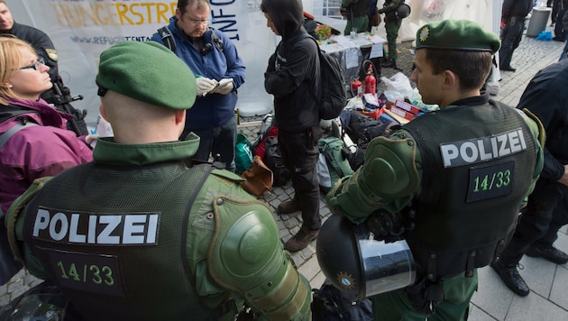 Deutsche Polizisten kontrollieren die Papiere von Flüchtlingen. (Bild: APA/dpa/Peter Kneffel)