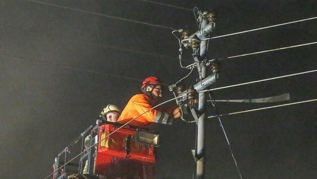 Der Salzburg-AG-Mitarbeiter auf der Drehleiter beim Abklemmen der Stromleitung. (Bild: Markus Tschepp)