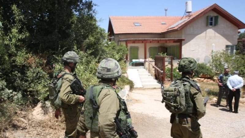 Das Haus, in dem der Mord passiert war, wurde später von israelischen Soldaten umringt. (Bild: APA/AFP/MENAHEM KAHANA)