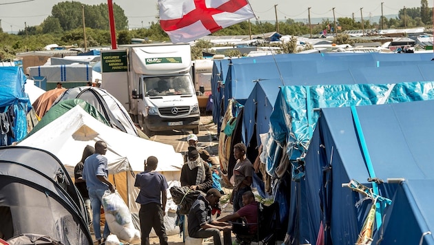 Die englische Flagge weht über dem provisorischen Flüchtlingslager in Calais. (Bild: APA/AFP/PHILIPPE HUGUEN)