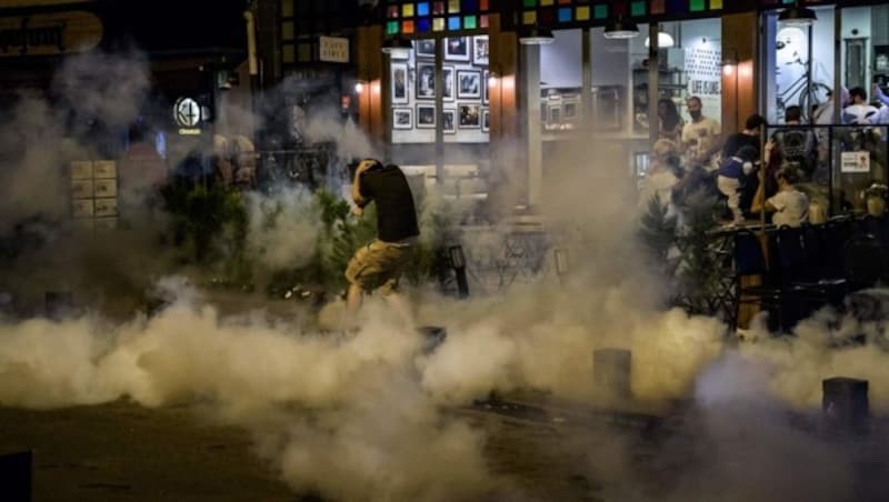 Protestierende bringen sich vor Tränengasgranaten in Sicherheit (Bild: APA/AFP/OZAN KOSE)