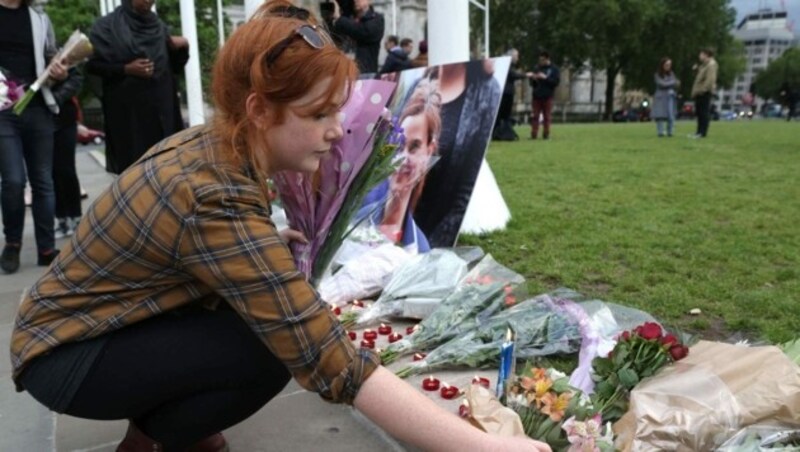 Trauernde stellen Kerzen und legen Blumen vor dem Parlament in London ab. (Bild: APA/AFP/DANIEL LEAL-OLIVAS)