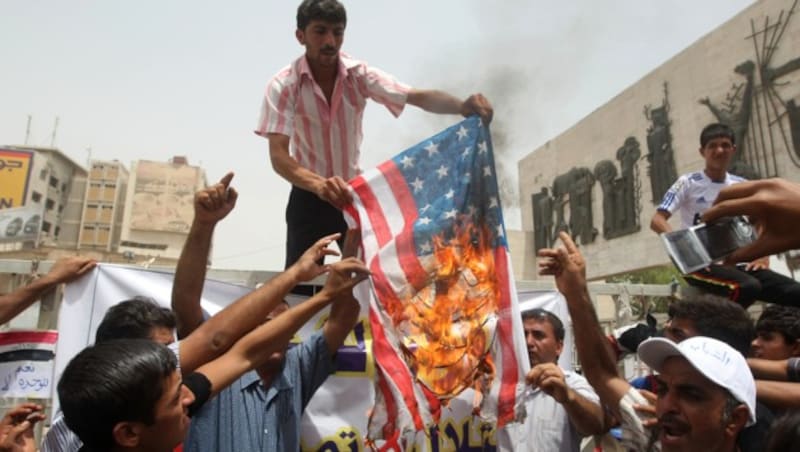 Männer im Irak verbrennen eine US-Flagge. (Bild: AHMAD AL-RUBAYE/AFP/picturedesk.com)