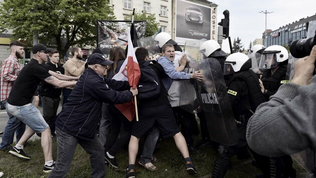 Hooligans und Ultranationalisten attackieren die Polizei. (Bild: APA/AFP/PAP/Adam Warzawa)
