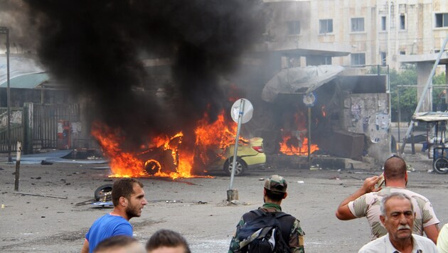Im syrischen Tartus brennt ein Auto, mit dem sich ein Attentäter in die Luft jagte. (Bild: Associated Press)