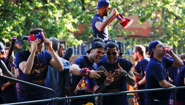 Die Barca-Superstars fuhren im offenen Bus durch die Stadt und ließen sich feiern. (Bild: AP)