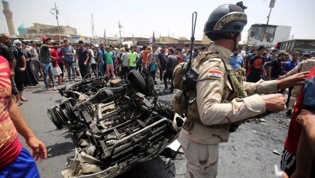 Irakischer Soldat drängt Schaulustige vom Tatort in Sadr-City weg. (Bild: APA/AFP/AHMAD AL-RUBAYE)