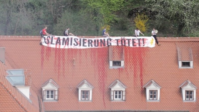 Vier Männer entrollten auf dem Dach des Gebäudes ein Plakat mit den Worten: "Islamisierung tötet". (Bild: APA/Grüne Steiermark)