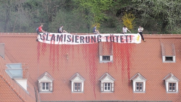 Vier Männer entrollten auf dem Dach des Gebäudes ein Plakat mit den Worten: "Islamisierung tötet". (Bild: APA/Grüne Steiermark)