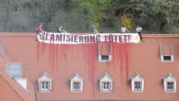 Vier Männer entrollten auf dem Dach des Gebäudes ein Plakat mit den Worten: "Islamisierung tötet". (Bild: APA/Grüne Steiermark)