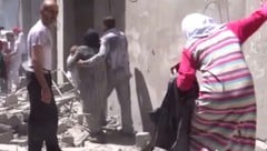 Menschen vor einem bombardierten Krankenhaus in Aleppo (Archivbild) (Bild: AP)