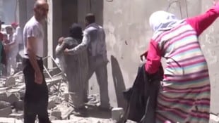 Menschen vor einem bombardierten Krankenhaus in Aleppo (Archivbild) (Bild: AP)