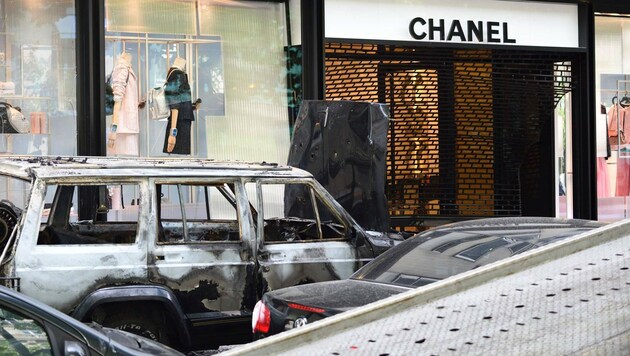 Der ausgebrannte Wagen vor dem Chanel-Shop (Bild: APA/AFP/Eric Feferberg)
