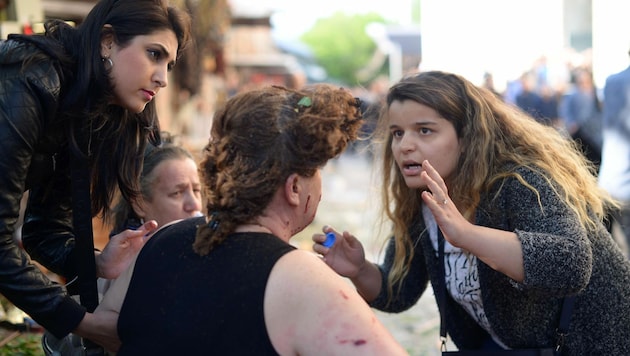 Passanten leisteten nach der Explosion sofort Erste Hilfe. (Bild: APA/AFP/Onur Yurtsever)