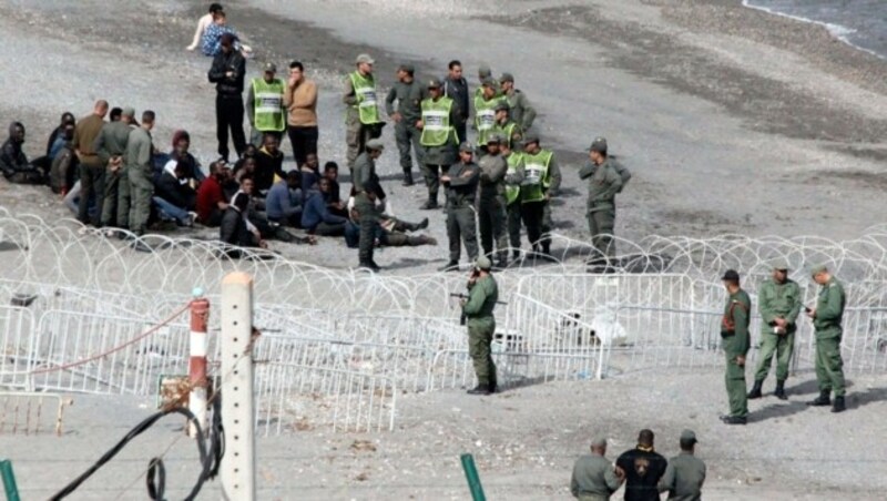 Flüchtlinge vor dem Grenzzaun zu Ceuta (Bild: EPA)