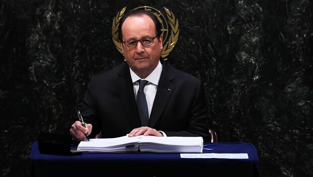 Francois Hollande unterzeichnet das Klimaabkommen. (Bild: APA/AFP/JEWEL SAMAD)