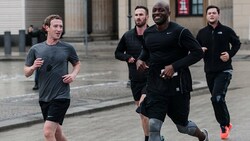 Mark Zuckerberg, flankiert von seinen Bodyguards, beim Joggen in Berlin (Bild: EPA)