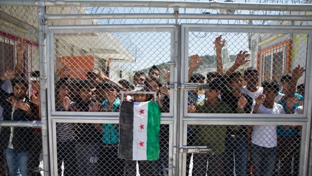 Flüchtlinge hinter einem versperrten Tor des Camps Moria auf Lesbos (Bild: ASSOCIATED PRESS)