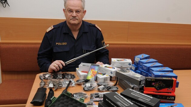 Ermittler Christian Lackstätter von der Polizei Kufstein mit den sichergestellten illegalen Waffen. (Bild: ZOOM-TIROL)