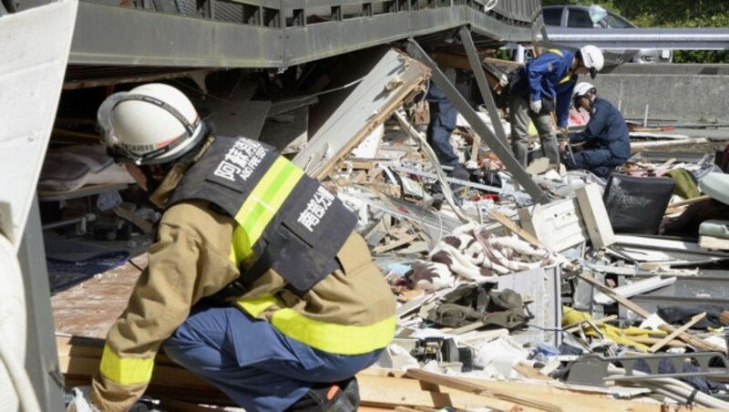 Helfer suchen unter einem eingestürzten Haus nach Verschütteten. (Bild: Associated Press)