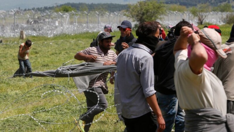 Flüchtlinge am Grenzzaun in Idomeni (Bild: AP)