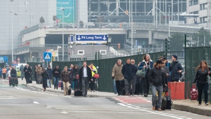 Passagiere verlassen den Flughafen in Brüssel. (Bild: APA/AFP/JOHN THYS)