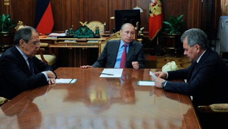 Putin mit Außenminister Sergej Lawrow (li) und Verteidigungsminister Sergej Schoigu (re) (Bild: AP)